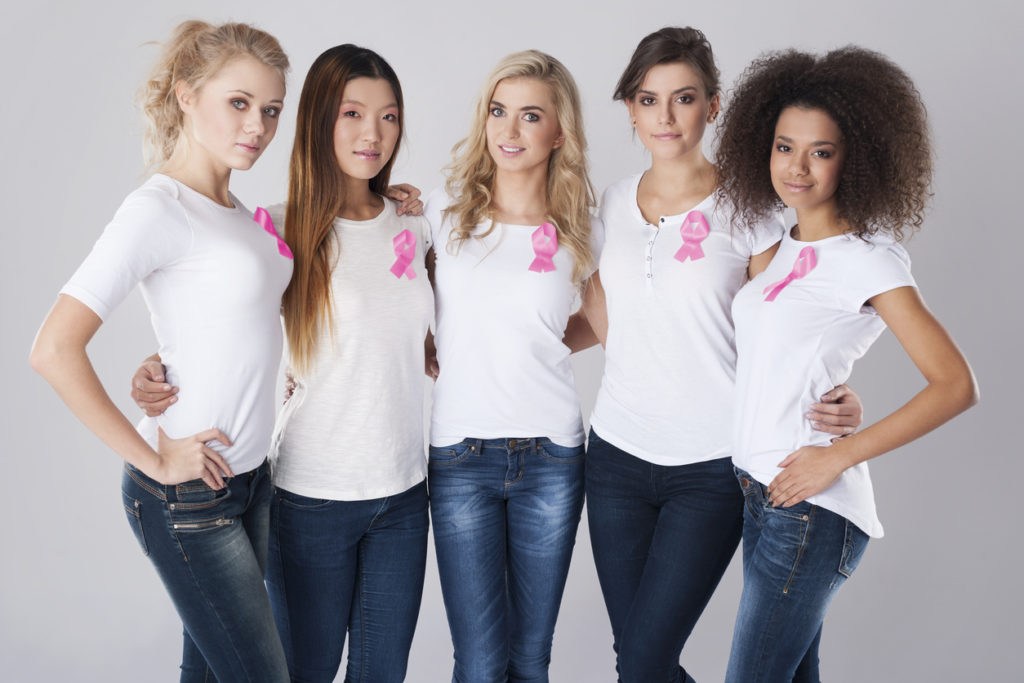 5 women standing wearing white tshirts and jeans